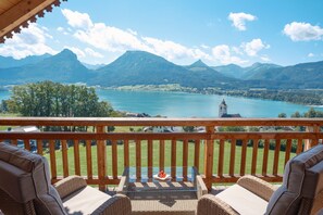 A balcony with wicker furniture overlooking a lake and mountains. - Altroiterhof (Sankt Wolfgang im Salzkammergut)