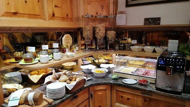 Un aparador ple d'una varietat d'aliments i una màquina de cafè.