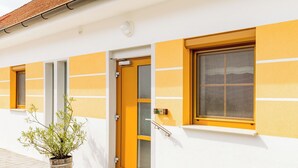 A building with a yellow and white facade, a door, and a window.