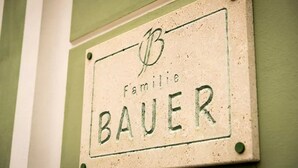 A sign with the name "Familie Bauer" on a wall. - Familie Bauer – Bioweingut Bauer (Großriedenthal)