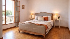 Een slaapkamer met een houten bed, twee nachtkastjes met lampen, een raam met gordijnen en een balkon.