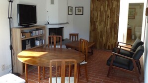 A living room with a fireplace, wooden furniture, and a television. - Calluna House, terrace in the sun of Onsernone (Auressio)