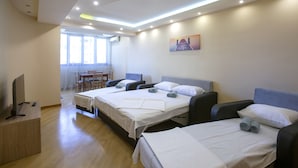 Una habitación de hotel con dos camas, un escritorio, una silla y un televisor.