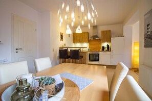 Eine moderne Küche mit Holzausstattung, integriertem Backofen und Pendelleuchten.