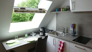 A kitchen with a skylight, a coffee maker, a sink, and a window overlooking greenery. - Small vacation apartment at Wulfkamp (Velen)