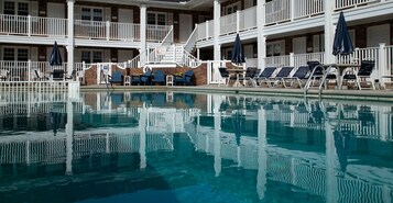 Una piscina al aire libre de temporada, sombrillas
