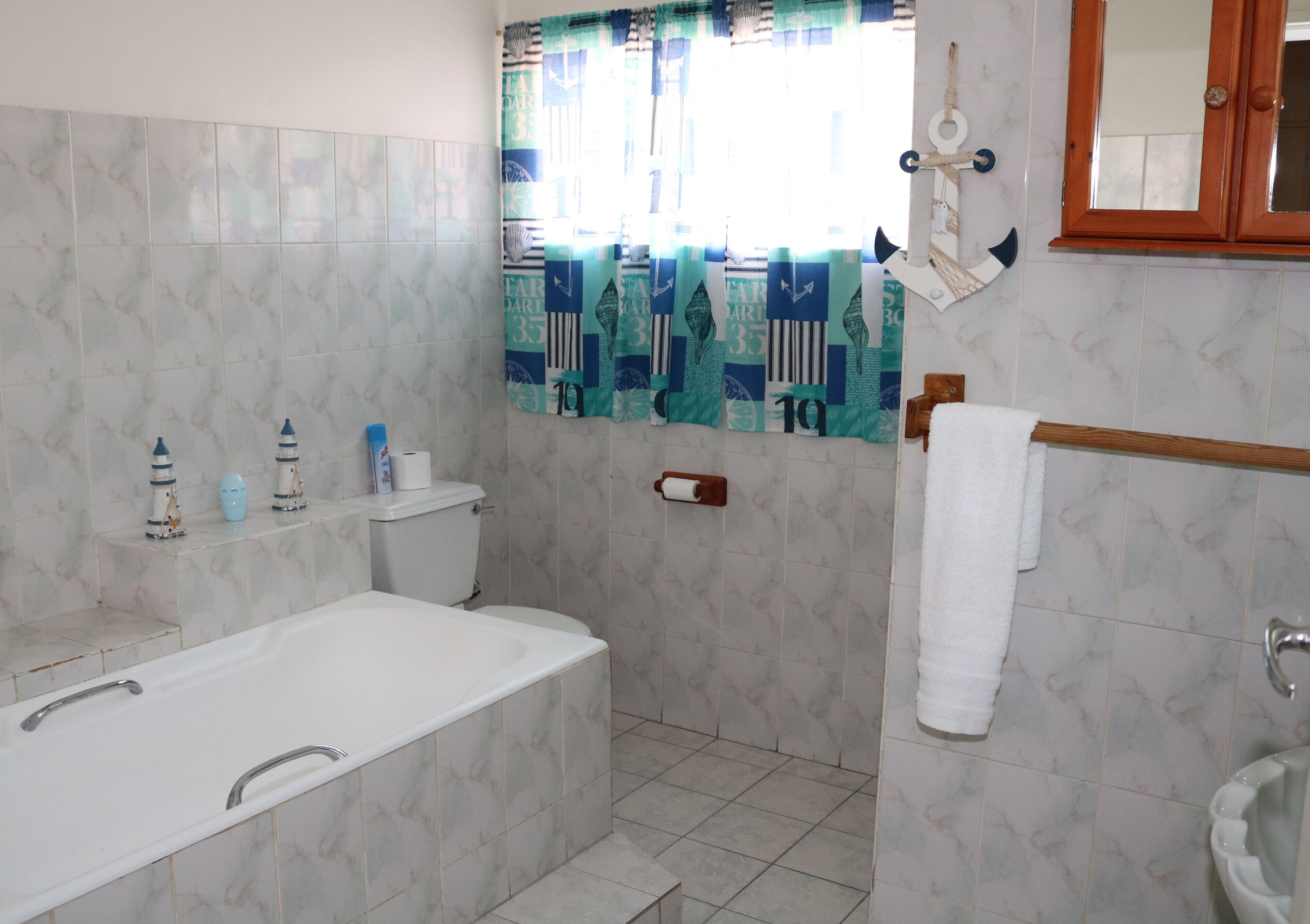 A bathroom with a bathtub, toilet, and sink.