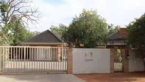 Una entrada con reja y un cartel que dice "19 CALEDON".