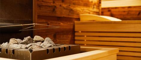 A sauna with a wooden interior and a stone heating element.