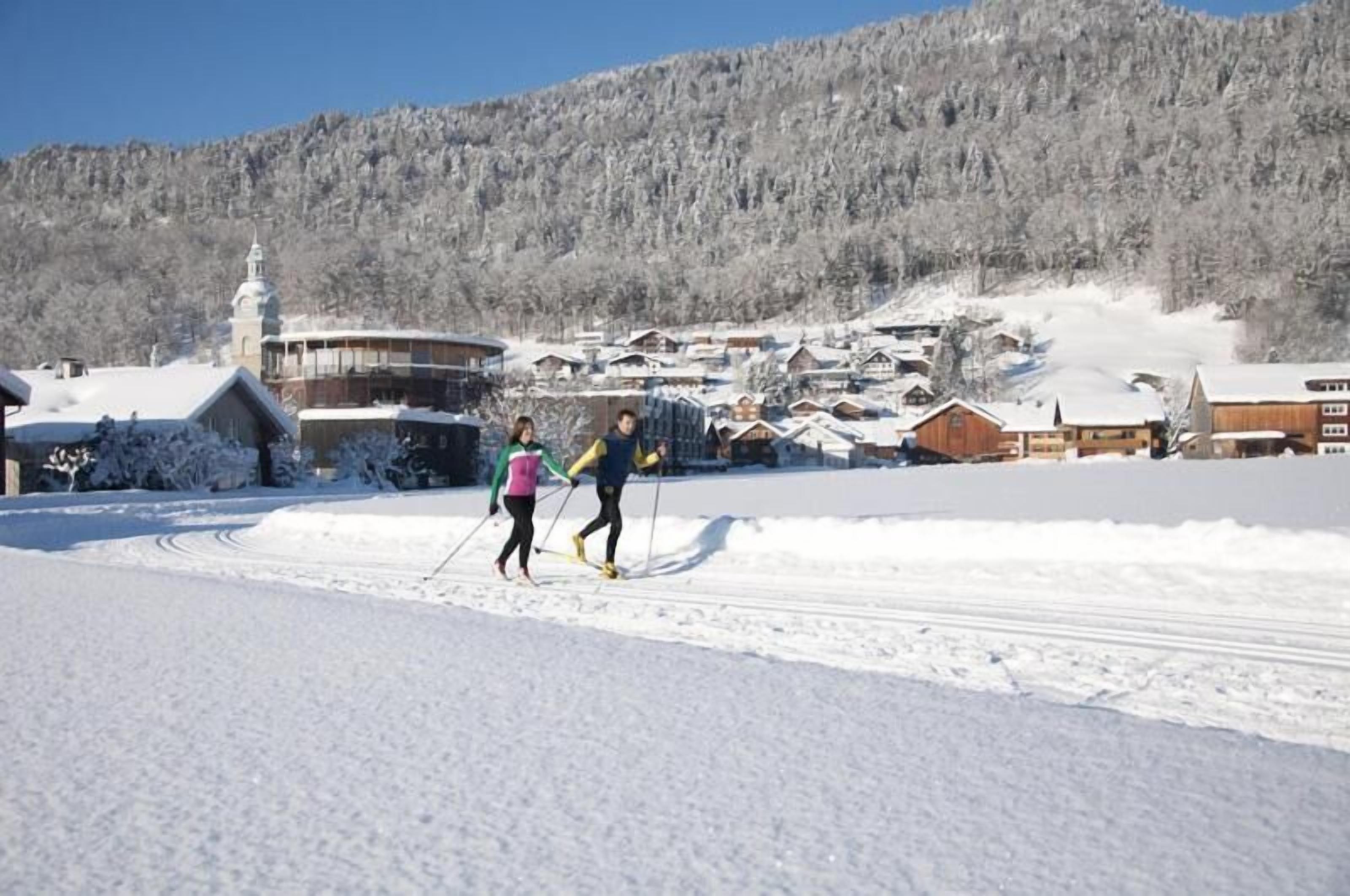 A snowy village with traditional wooden houses and a church.