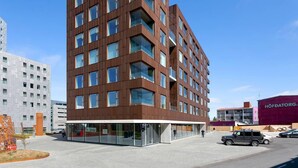 Un edificio moderno de varios pisos con fachada marrón y ventanas grandes.