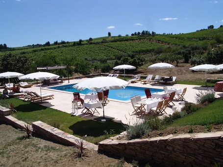 Una piscina al aire libre, sillones reclinables de piscina