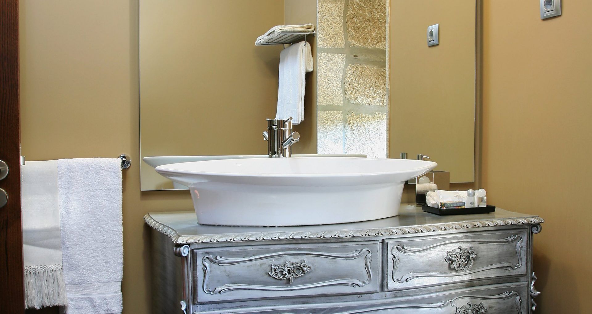Une salle de bain avec un grand lavabo ovale, un miroir et un meuble-lavabo avec des tiroirs.