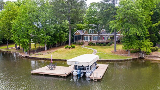 A house with a dock extending into a lake, surrounded by trees. - Lovely Lake Escape on Lake Oconee with game room, hot tub and fire pit (Eatonton)