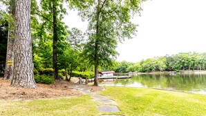 A park with a lake, stone steps, and a red-roofed building. - Lovely Lake Escape on Lake Oconee with game room, hot tub and fire pit (Eatonton)