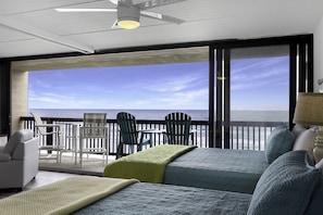 Enjoy ocean views from the balcony, featuring two beds and a seating area.