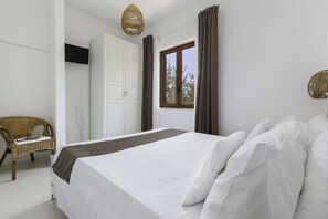 Ein Schlafzimmer mit Bett, Stuhl, Kleiderschrank und Fenster.
