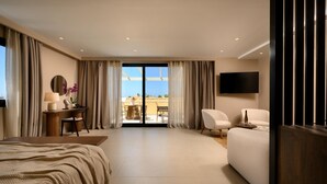 A modern hotel room with a bed, a desk with a lamp, a TV, a sofa, and a balcony with outdoor seating. - Restia (Corfu)