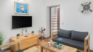 Una sala de estar moderna con televisor de pantalla plana, muebles de madera, un sofá y una mesa de centro.