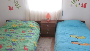 A bedroom with two beds, a nightstand, and a window with curtains. - Between Nazareth and S. Pedro de Moel (Pataias)