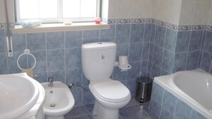 A bathroom with a toilet, bidet, sink, and bathtub. - Between Nazareth and S. Pedro de Moel (Pataias)