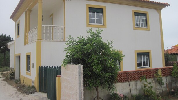 A two-story house with a balcony, a small garden, and a red-tiled roof. - Between Nazareth and S. Pedro de Moel (Pataias)