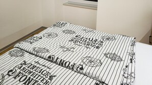 Quarto com cama, janela e um objeto decorativo na parede.