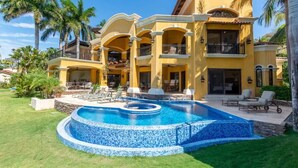 A large, two-story house with a swimming pool and outdoor seating area.