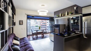 Una cocina moderna con horno empotrado, refrigerador y comedor con mesa y sillas.
