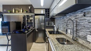 Una cocina moderna con electrodomésticos de acero inoxidable, encimera de granito y salpicadero con diseño de mosaico.
