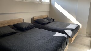 A bedroom with two beds, a skylight, and a view of the outside. - Furnished duplex studio with air-conditioned parking space (Surgères)