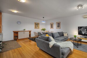 Deluxe appartement, 1 kingsize bed met slaapbank, terras, uitzicht op zee | Woonruimte | Een televisie