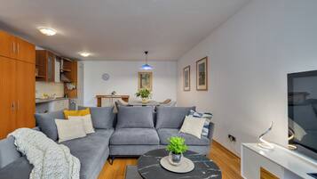 Deluxe appartement, 1 kingsize bed met slaapbank, terras, uitzicht op zee | Woonruimte | Een televisie
