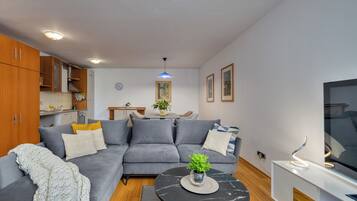 Leilighet – deluxe, 1 kingsize-seng med sovesofa, terrasse, sjøutsikt | Oppholdsområde | TV