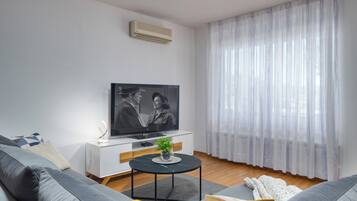 Deluxe appartement, 1 kingsize bed met slaapbank, terras, uitzicht op zee | Woonruimte | Een televisie