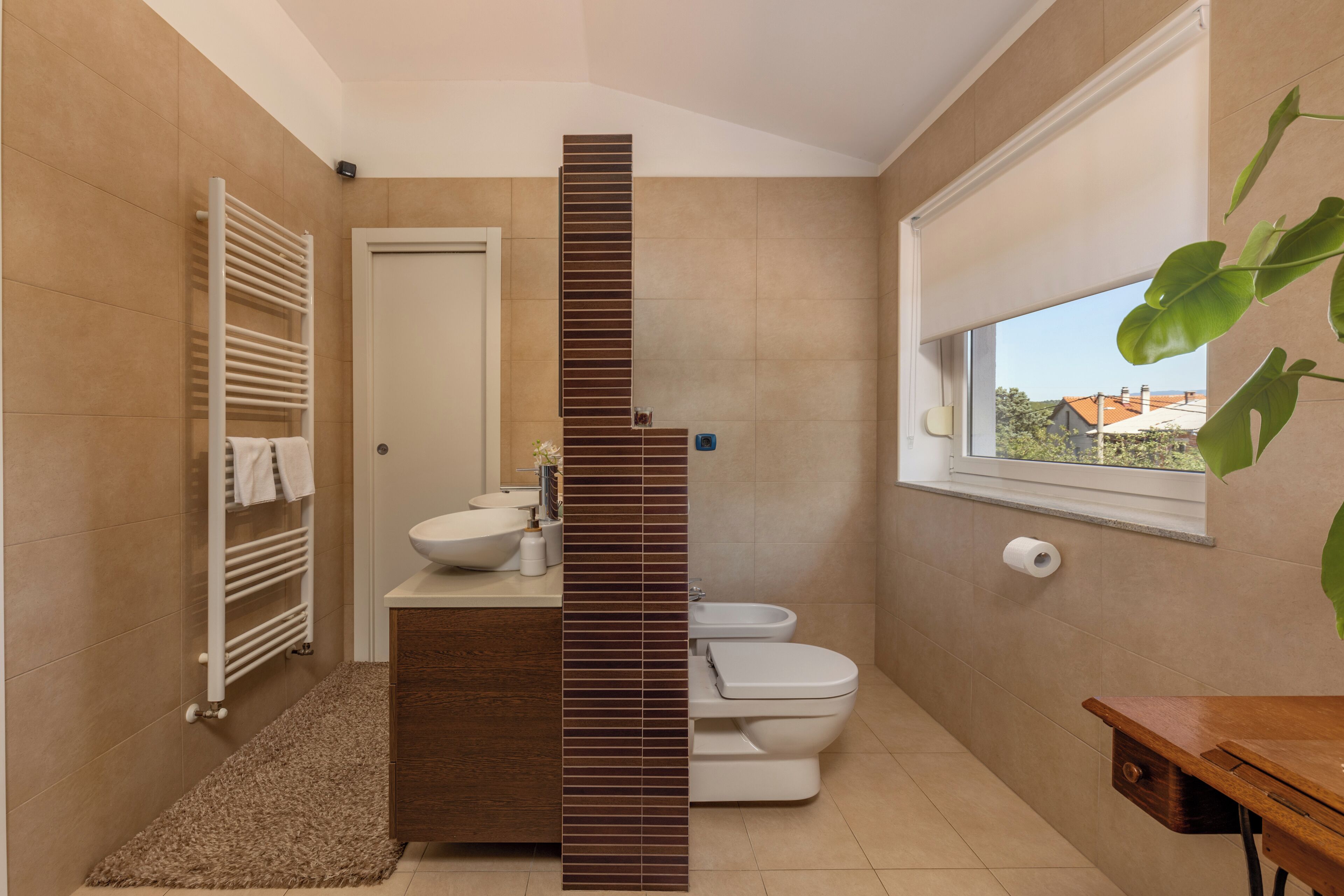 Uma casa de banho moderna com lavatório embutido, sanita e suporte para toalhas.
