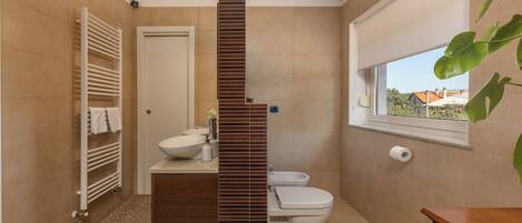 A modern bathroom with a built-in sink, a toilet, and a towel rack.
