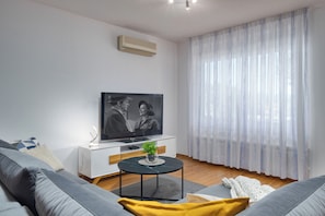 Apartamento luxo, 1 cama King e sofá-cama, terraço, vista para o mar | Área de estar | TV