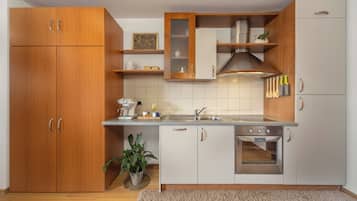 A modern kitchen with wooden cabinets, a built-in oven, and a sink.
