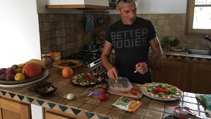 Una cocina con salpicadero de azulejos, una estufa y diversos alimentos sobre la encimera.