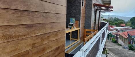 Paredes externas de madeira de um edifício com uma varanda com vista para a rua.