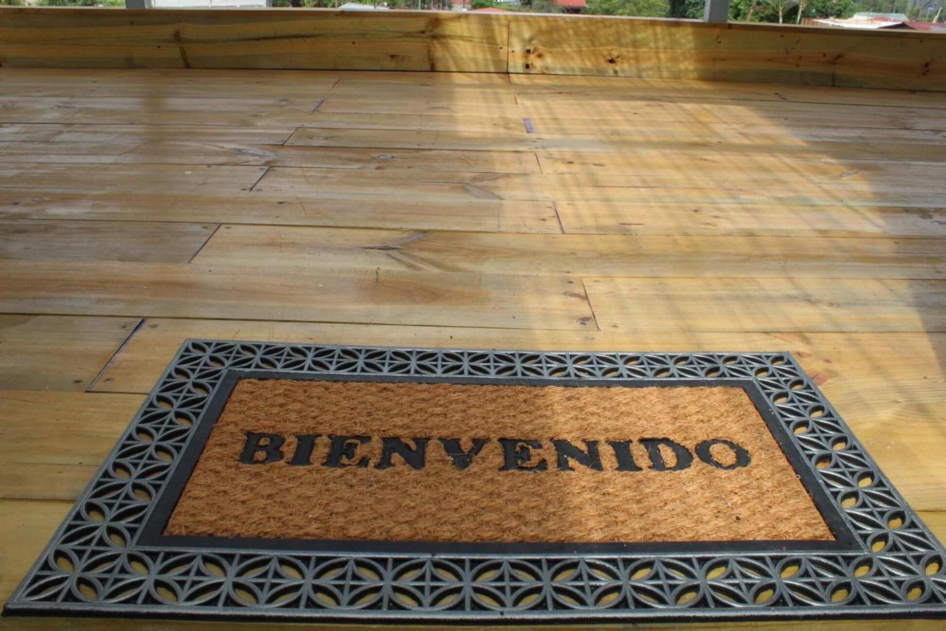 A wooden deck with a welcome mat.