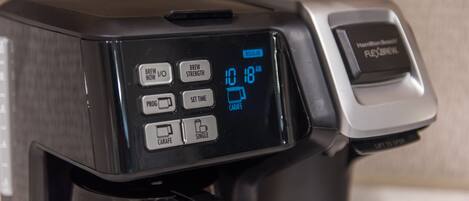 A coffee maker with a digital display showing "10:18 AM" and options like "BREW NOW," "BREW STRENGTH," "PROG," "SET TIME," "CARAFE," and "SINGLE."