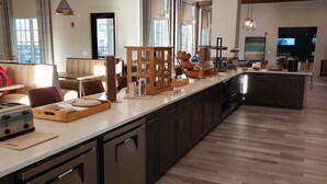 A modern kitchen with a long counter, built-in appliances, and a central island. - Silver Collection Hotel (Fredericksburg)