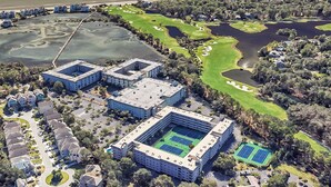 Ein moderner Hotelkomplex mit mehreren Gebäuden, einem Golfplatz und Tennisplätzen.