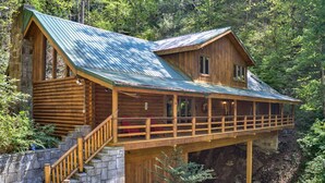 A log cabin with a balcony, stone steps, and a metal roof. - Black Bear Lodge by Vtrips (Cosby)