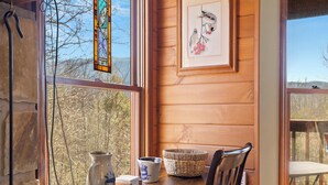 A wooden interior with a table, chairs, a vase, and a framed artwork. - Annie's Smoky View by Jackson Mountain Rentals (Gatlinburg)