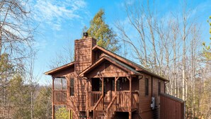 A wooden cabin with a porch, a chimney, and a garage. - Annie's Smoky View by Jackson Mountain Rentals (Gatlinburg)