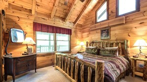 Une chambre dans une cabane en bois, avec un lit, une commode et deux lampes.