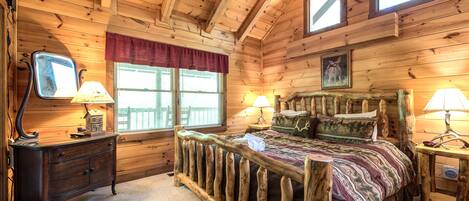 Un dormitorio de cabaña de madera con cama, cómoda y dos lámparas.